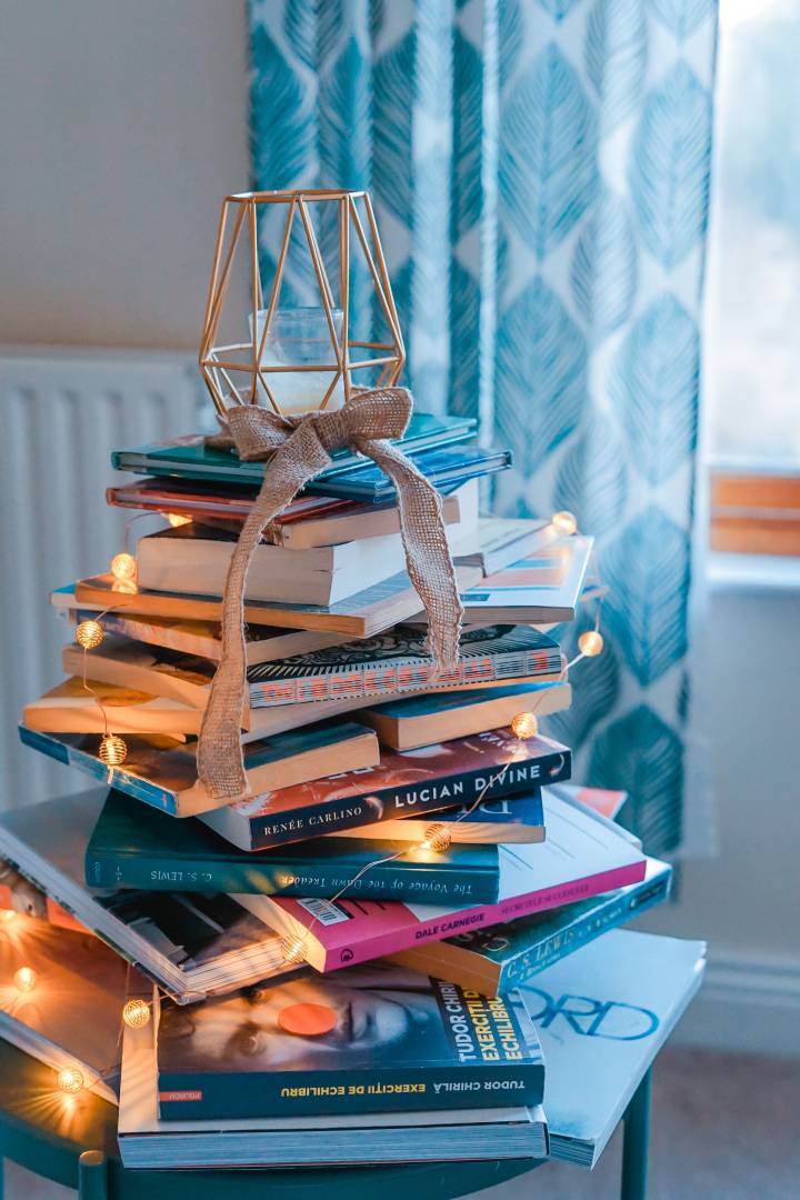 Stack Of Books With Lights And A Candle On Top