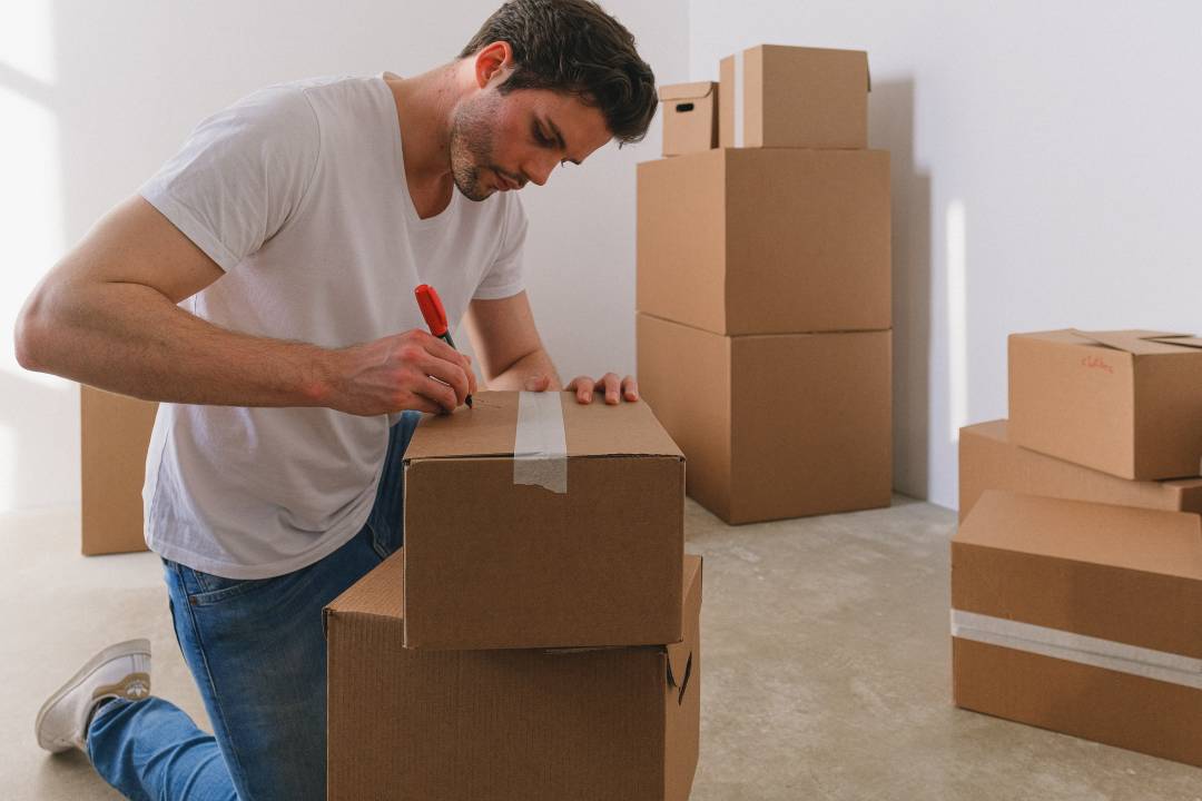 Man Writing On A Cardboard Box