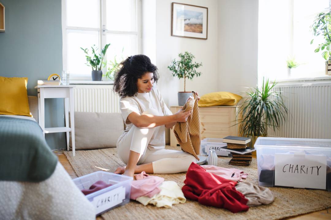 Person Listening To Music While Looking At Clothes With A Charity Box