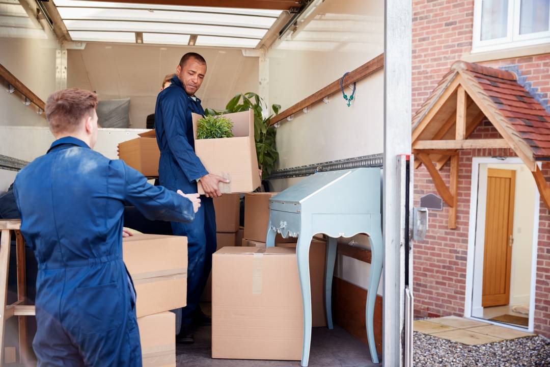 Moving Men Taking Boxes Out Of A Van