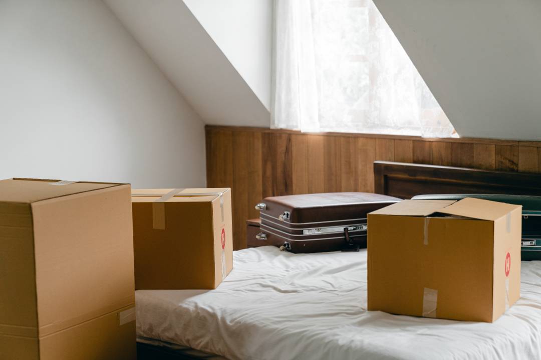 Boxes and Suitcase On A Bed